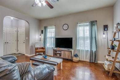 Living room with a ceiling fan, finished concrete