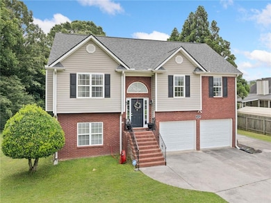 Raised ranch featuring concrete driveway, brick siding, a garage, and roof with shingles