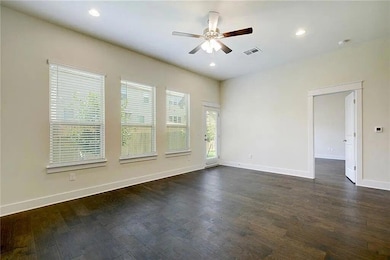 Empty room with a ceiling fan, baseboards, dark w