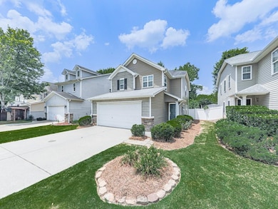 View of front of property with driveway, stone siding, and a garage