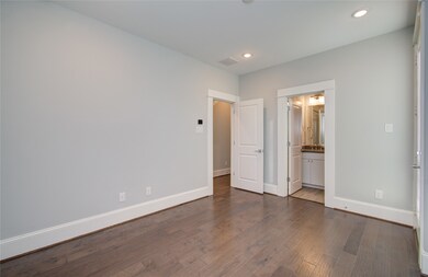 The room features neutral walls, dark hardwood flo