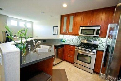 Kitchen features modern glass mosaic tile back spl