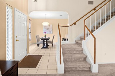 Entryway with arched walkways, stairs, light tile
