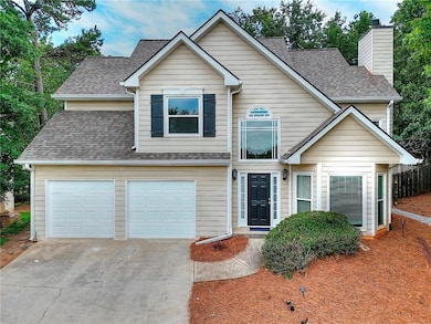 Traditional-style home with driveway, a chimney, a shingled roof, and a garage
