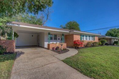 Single story home with a front lawn and a carport