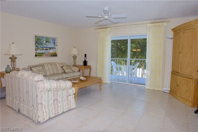 SPACIOUS TILED LIVING AREA HAS DIRECT LANAI ACCESS AND CANAL/WATER VIEWS.