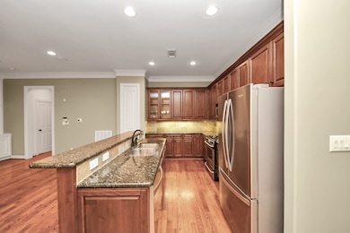 This kitchen features elegant wooden cabinets, stainless steel appliances including a refrigerator and gas stove.