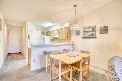 Dining room with light carpet and a notable chandelier