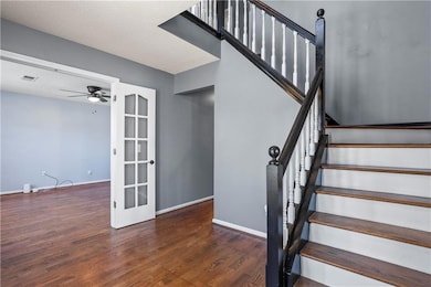 Stairs with visible vents, baseboards, ceiling fan