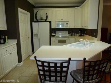 Kitchen. So many cabinets in this bright and beautiful kitchen!  Like new tiled floors, corian countertops and coffee bar.