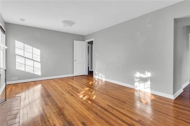 Spare room with hardwood / wood-style flooring and baseboards