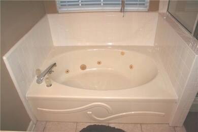 The jetted tub in the Owners Suite bath which also features tile floors, separate shower and double vanities
