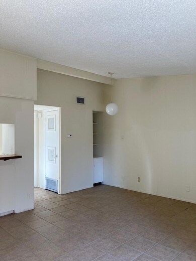 Unfurnished living room featuring a textured ceil
