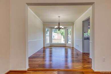 Unfurnished dining area featuring ornamental molding, wood finished floors, and a chandelier
