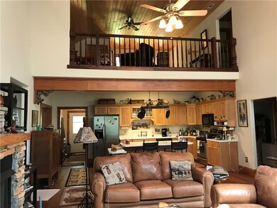 Living room with loft above and kitchen with bar