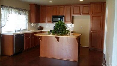 Kitchen with large window view of side yard.