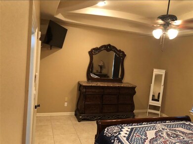 Bedroom featuring ceiling fan and light tile floors