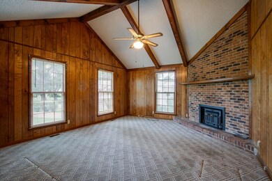 Living room with vaulted beamed ceiling and brick fireplace