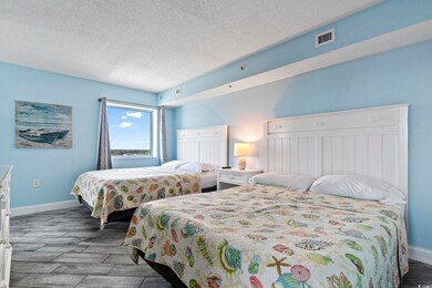 Bedroom featuring a textured ceiling and light har