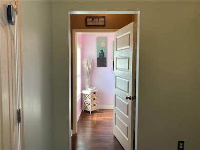 Corridor with dark wood-type flooring and plenty of natural light