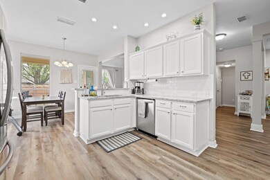 Kitchen with dishwasher, an inviting chandelier, w