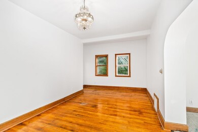 Spare room with a notable chandelier and hardwood 