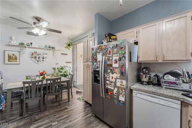 Kitchen with white dishwasher, light countertops, decorative backsplash, stainless steel refrigerator with ice dispenser, and dark wood-style floors