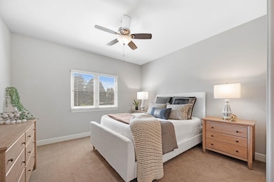 Bedroom featuring light colored carpet and a ceiling fan