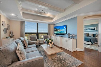 Living room featuring dark hardwood / wood-style flooring, crown molding, and an inviting chandelier