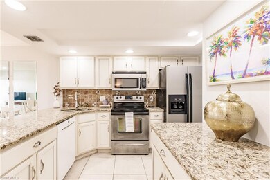 Kitchen with tasteful backsplash, light stone coun
