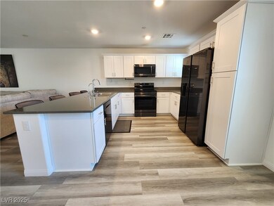 Kitchen with black appliances, dark countertops, l