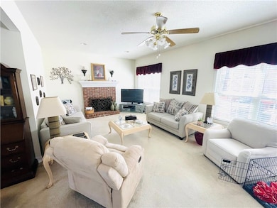 Living area with light carpet, a textured ceiling,
