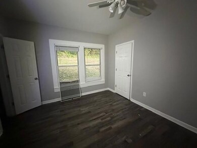 Unfurnished bedroom with dark wood finished floors, a ceiling fan, and a closet