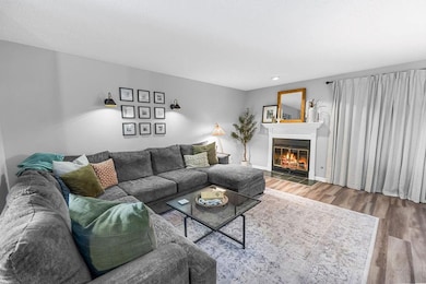 Living area featuring wood finished floors and a glass covered fireplace