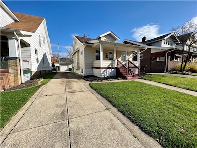 Bungalow-style house featuring a garage, covered porch, and a front lawn