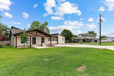 Rear view of house featuring a chimney, driveway,