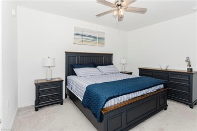 Bedroom with light colored carpet, baseboards, and ceiling fan