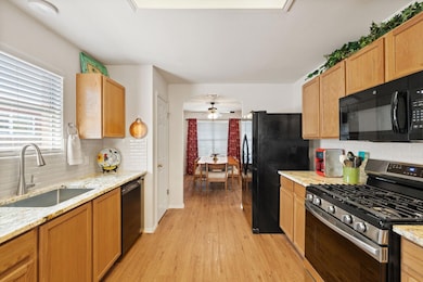 Kitchen featuring a sink, a ceiling fan, light wo