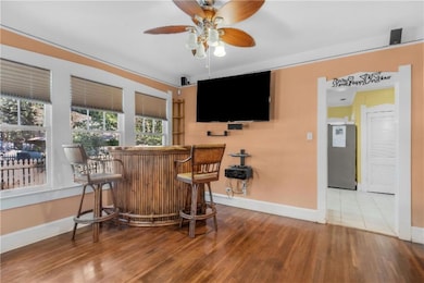 Bar with hardwood / wood-style flooring, ceiling f
