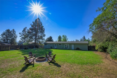 Back of property featuring a fenced backyard, an outdoor fire pit, a patio, and stucco siding