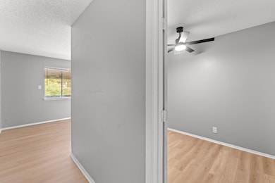 Hallway featuring baseboards, wood finished floor