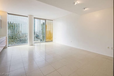 Spare room featuring a wall of windows and light t