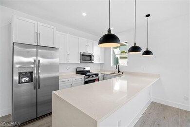 Kitchen with sink, white cabinetry, appliances wit