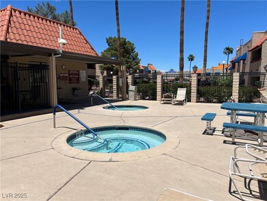 View of swimming pool featuring a hot tub, fence,