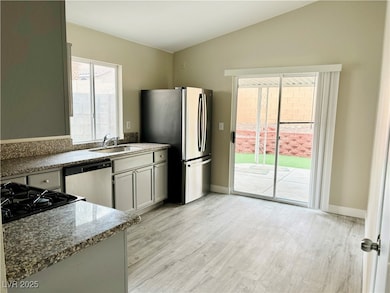 Kitchen with dishwasher, a sink, freestanding refr