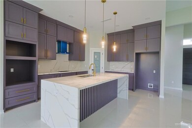 Kitchen with light stone countertops, a center island with sink, backsplash, wall chimney range hood, and sink