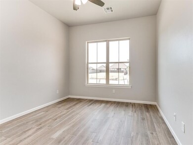 Unfurnished room featuring light wood-style floors, a ceiling fan, and baseboards