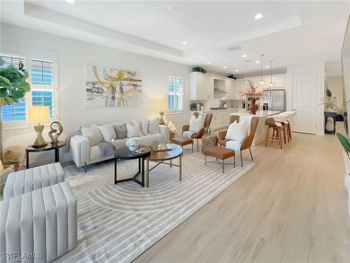 Living room featuring a raised ceiling, light wood