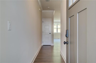 Hall with visible vents, dark wood-type flooring, 