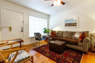 Living area featuring a ceiling fan, wood finishe